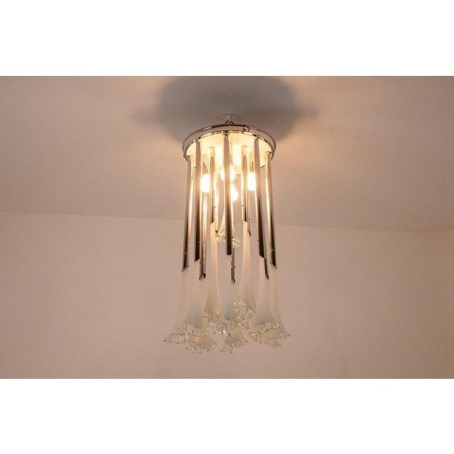 Murano glass chandelier with its flower-decorated tubes inserted into a circular chrome-plated metal frame. 1970s. This...