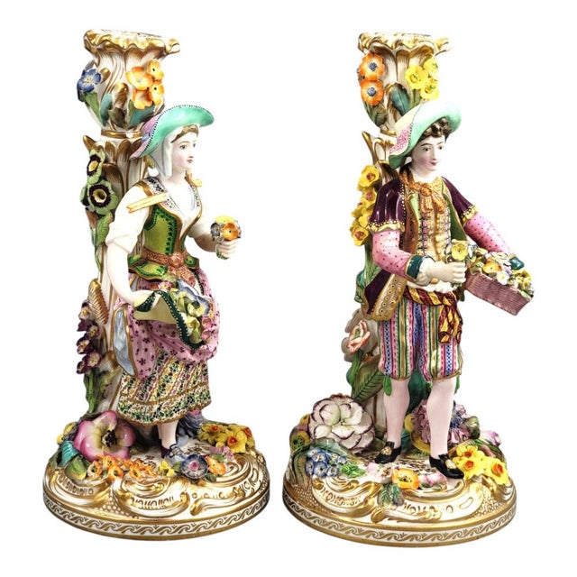 A rare pair of early Minton porcelain figural candlesticks representing a young flower seller and her companion, dating to...