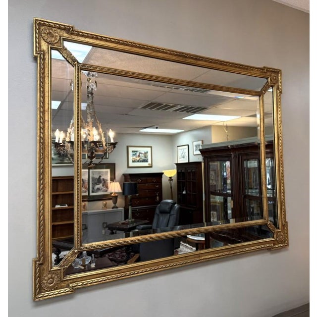 This Friedman Brothers-attributed Neoclassical wall mirror features a gilt frame with carved rosette accents, rope-twist...