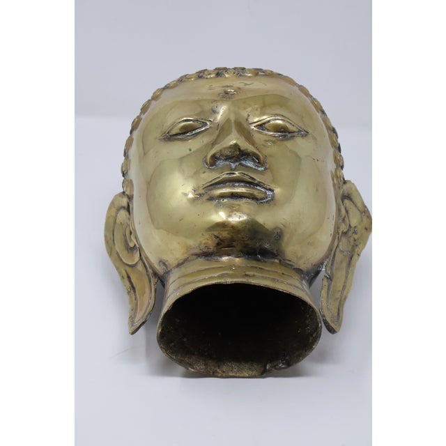 An exceptionally substantial, attributed Early 20th Century Southeast Asian hollow cast brass Buddha head distinguished by...