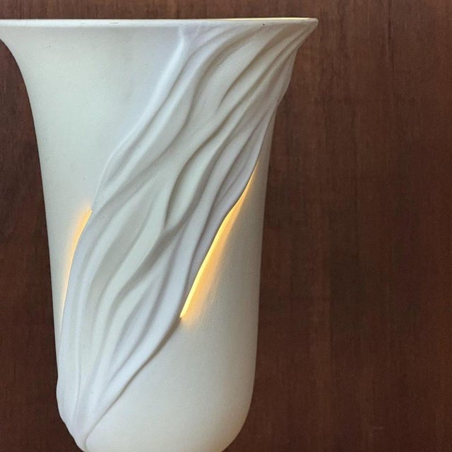 A dramatic ceramic italian uplighter in a soft matt tactile finish with draped detailing. Once illuminated the light glows...