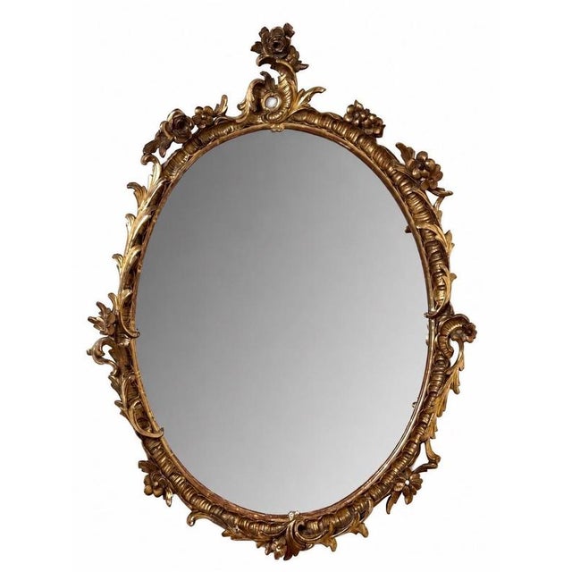An exceptional 19th century French hand-carved giltwood mirror of outstanding craftsmanship, showcasing the elegance and...