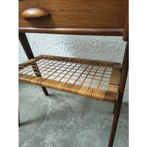Teak bedside table with a drawer and a wicker shelf, designed by Søren Rasmussen in the 1960s. The teak wood gives it a...