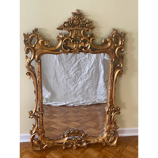 Vintage 20th Century Italian Rococo Style giltwood wall mirror with extensive foliate carved filigree frame with floral...