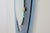 A mirror by Max Ingrand for Fontana Arte, 1950, with an asymmetrical shape in blue glass and brass joints. Franco Deboni,...