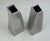 A set of 2 vintage 1990s modern aluminum vases. Abstract square form tapering at the top with a square opening, these...