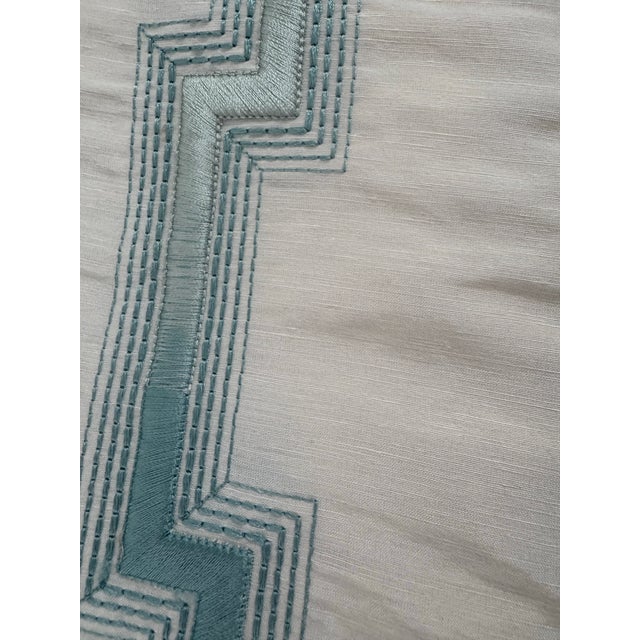 1.5 yards A striking embroidered silk fabric featuring a refined geometric fretwork pattern in soft aqua tones against an...