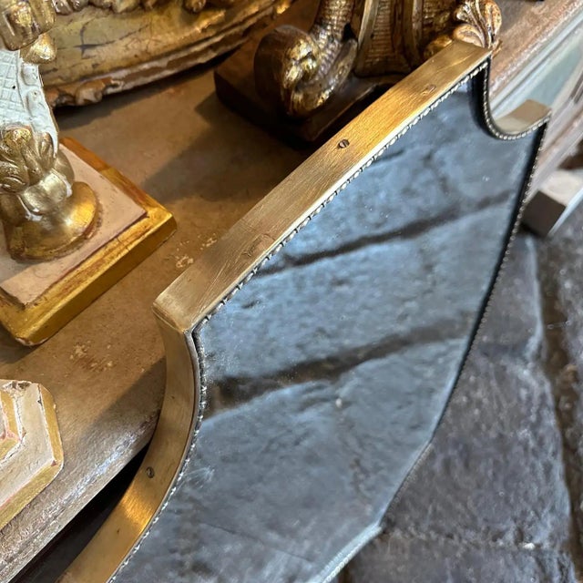 A shield shaped brass wall mirror designed and manufactured in Italy in the Sixties in the style of Giò Ponti, mirror is...