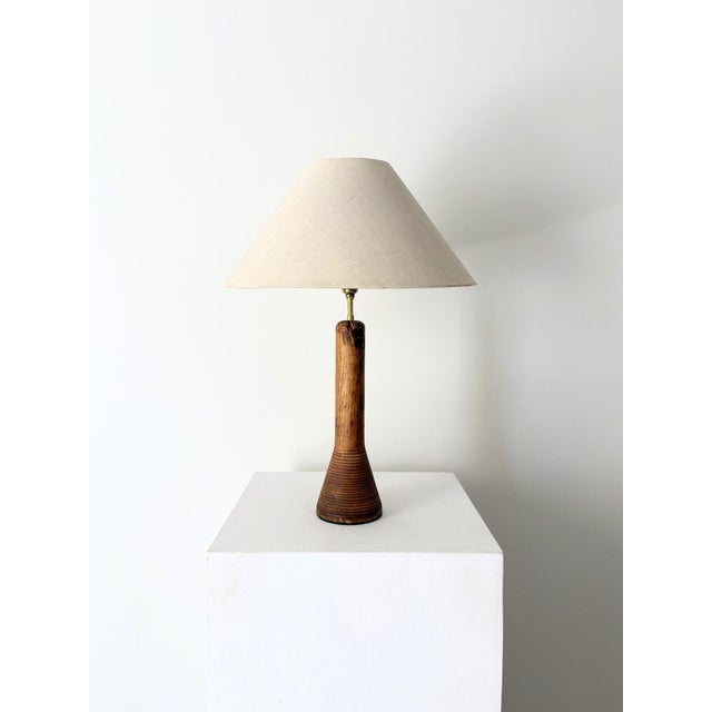 A striking table lamp formed from a vintage industrial loom spool, featuring concentric rings to the conical base. Solid...