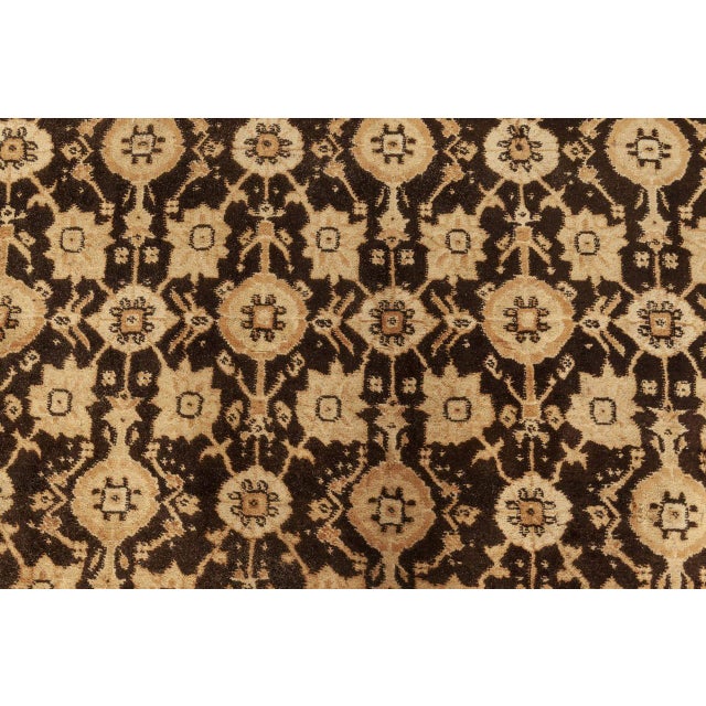 An early 20th century vintage agra rug, the chocolate brown field with a rosette, palmette and leafy vine trellis within...