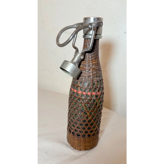 This rare antique 19th century French woven wicker, metal, and glass seltzer bottle is a unique collectible piece that...
