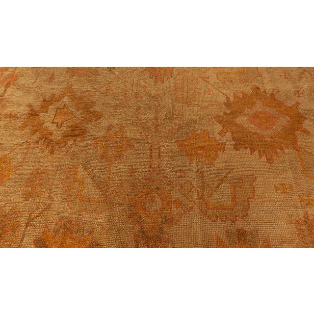 This antique Turkish Oushak rug embodies the richness and depth characteristic of Anatolian weaving traditions. Hand-...