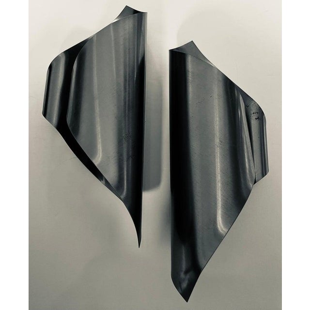 A great pair of French mid century wall lights done in folded steel in a sculptural manner. One 120 watt candelabra socket...