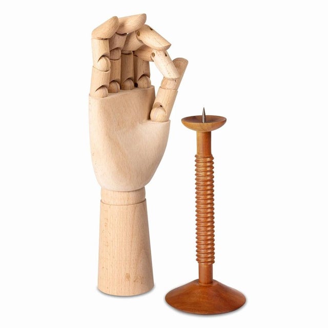 This is a wooden candlestick made by the artist Antonín Hepnar using a lathe. There is a nail at the top to hold the...