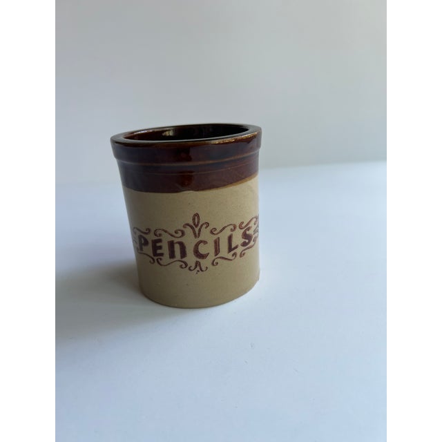 Small Brown and Tan Pencil Crock with the word "pencils" on the front. A great piece for a desk. Combined shipping available.