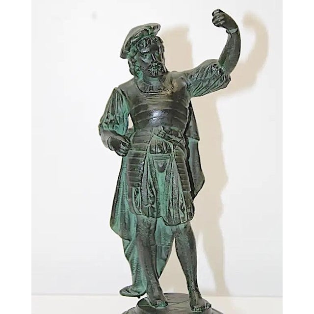 This circa early-20th-century spelter sculpture of a man depicted in the attire of a 17th- or 18th-century musketeer or...