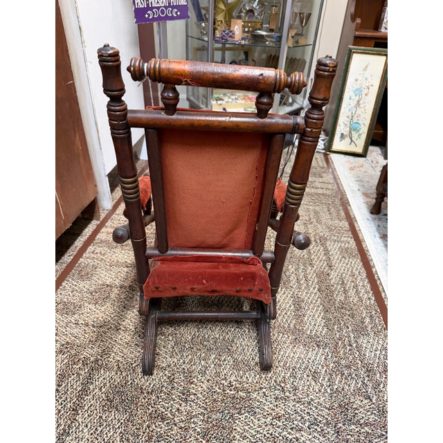 Crafted from dark turned wood with traditional spindle and spool turnings along the back and sides. Features a vibrant red...