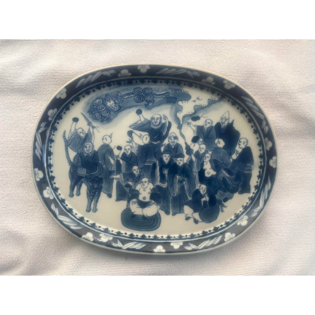 Blue and white Chinese export porcelain platter decorated with immortals celebrating. The border is a nawthorn pattern of...