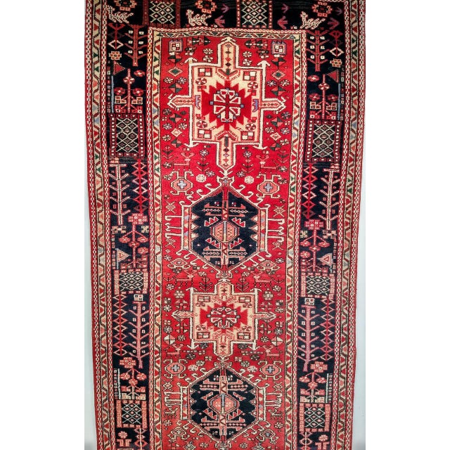 "A remarkable and generously proportioned antique Persian Heriz Karajeh runner, handwoven in the early 20th century in the...