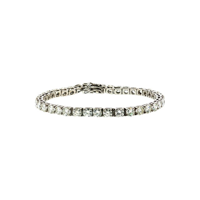 A 21st-century tennis bracelet featuring brilliant-cut white diamonds. The total carat weight of the 50 diamonds is...