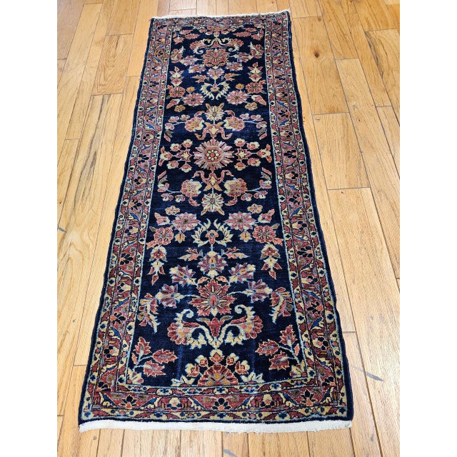 "An early 20th century Persian Lilian runner in an elegant allover floral design set in an abrash navy blue field of great...