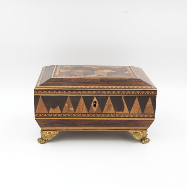 A Regency rosewood specimen box of rectangular form with shallow canted lid and chamfered upper edges. The top centered by...