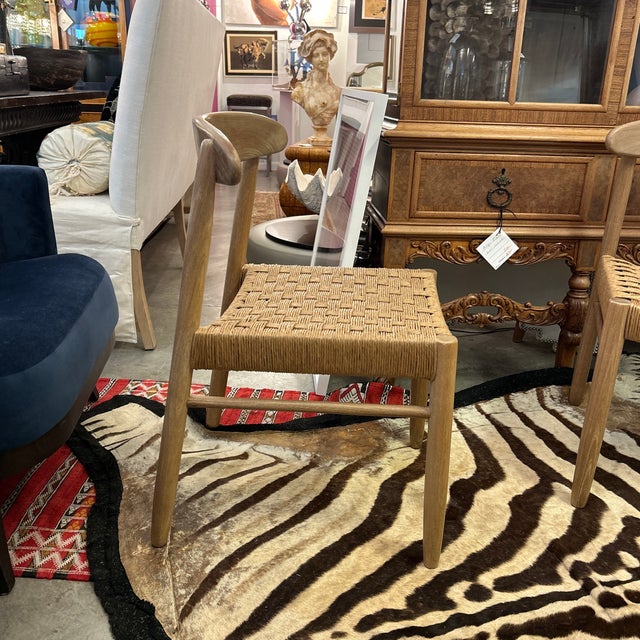 Mid century style blond wood frame chair with rush seat. The rush is done in a basket weave pattern. The chair has a...