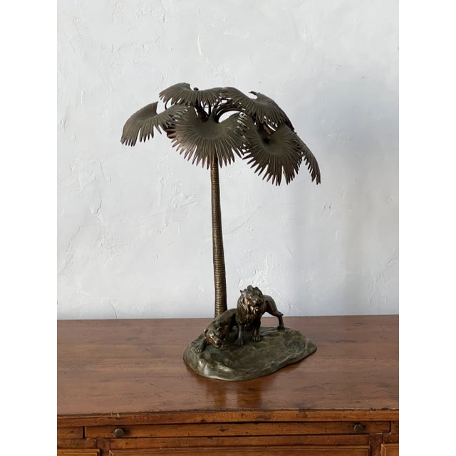 Rare bronze table lamp from Austria in the style of Bergman. This lamp features a pair of lions under a palm tree, with...