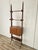 1960s teak veneered bookcase with an iron frame and uprights and adjustable brass feet. The piece features several holes...