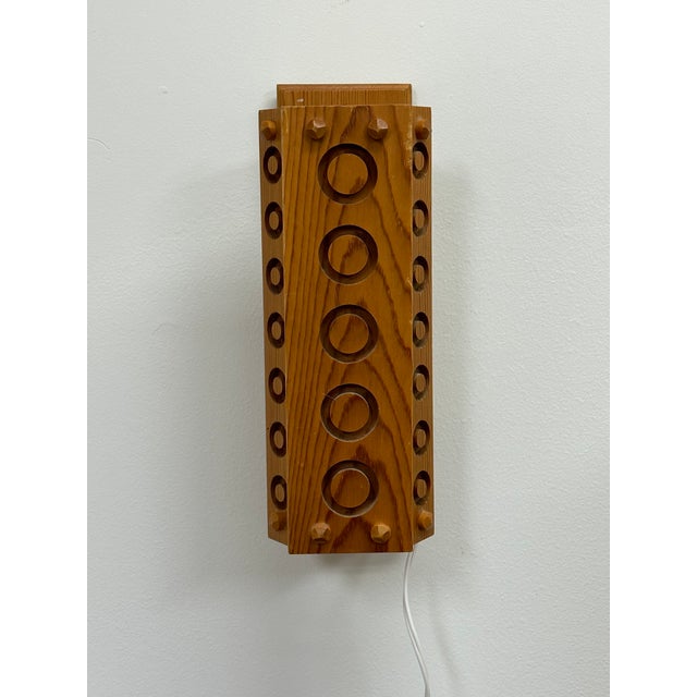 A wonderful Swedish Wall light constructed of Pine with routed circular patterns. Features a pivoting shade and light can...