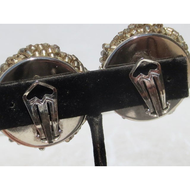 White metal and grey beads rolled into a ball cluster. Marked on the back under the clip-on. Matia Calderara, Italy circa...