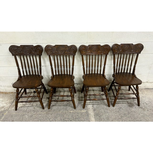 This is a gorgeous complete set of four vintage, possibly antique, oak lion head press back traditional dining chairs....