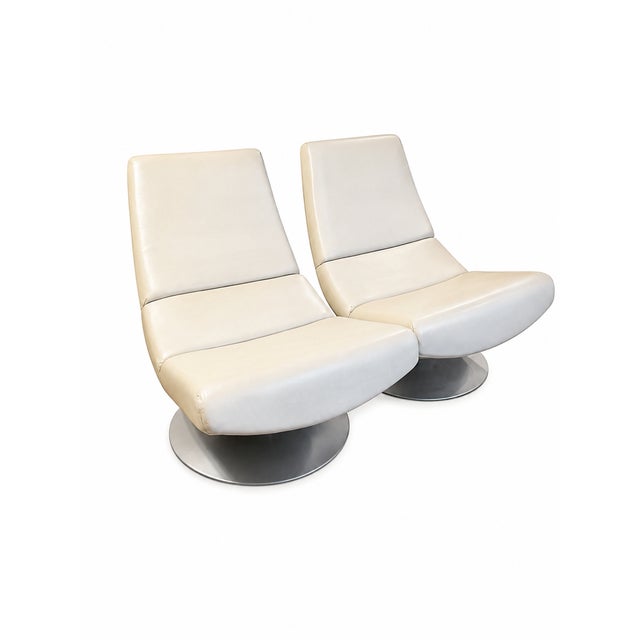 Mid century space age style swivel set of lounge chairs. They feature a metal round disc base. Possibly Vinyl or leather.
