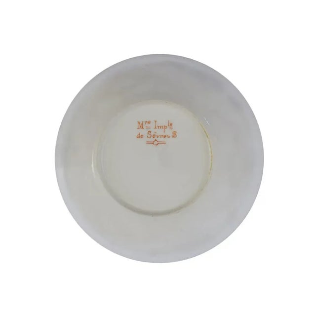 An exquisite Sevres porcelain demitasse cup and saucer embodying the elegance and refinement of the French Empire period....