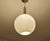 Very large mid century doria pendant light featuring a glass globe shade with a reliefed grid pattern, brass glass cap,...