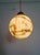 Art Deco pendant light composed of a speckled/veined satin-finish opaline globe and a brass frame, circa 1920s-30s. The...