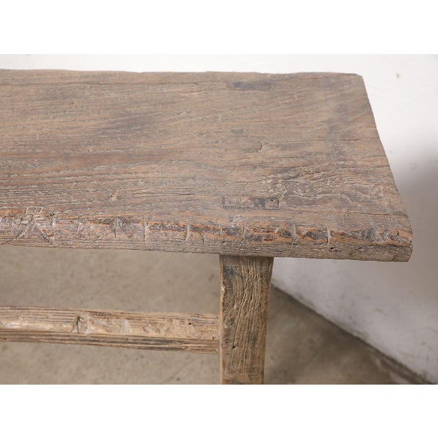 A beautifully rustic console table crafted from solid pinewood, dating to the first half of the 20th century. The long,...