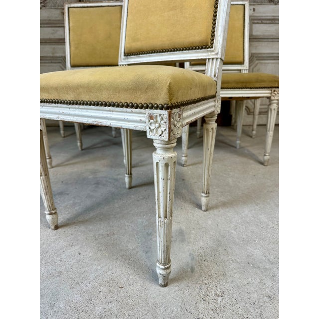 Set of six white lacquered louis xvi style chairs, circa 1900. Square backrest with a molded edge. Fluted front legs with...