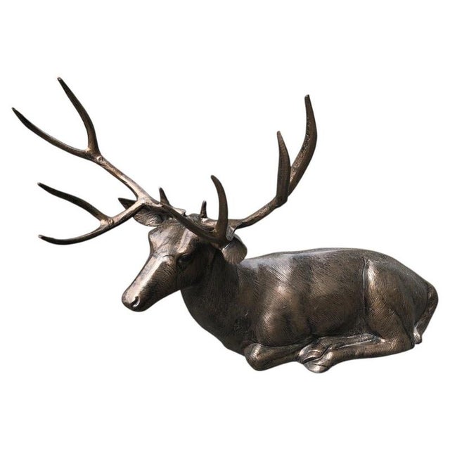 An impressive and highly decorative life-size reclining stag sculpture, beautifully modelled in a relaxed resting pose...