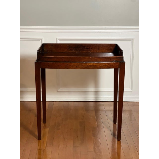 Handcrafted mahogany butler's serving tray with integrated handles on a stand, England, c. 1860. This server features a...
