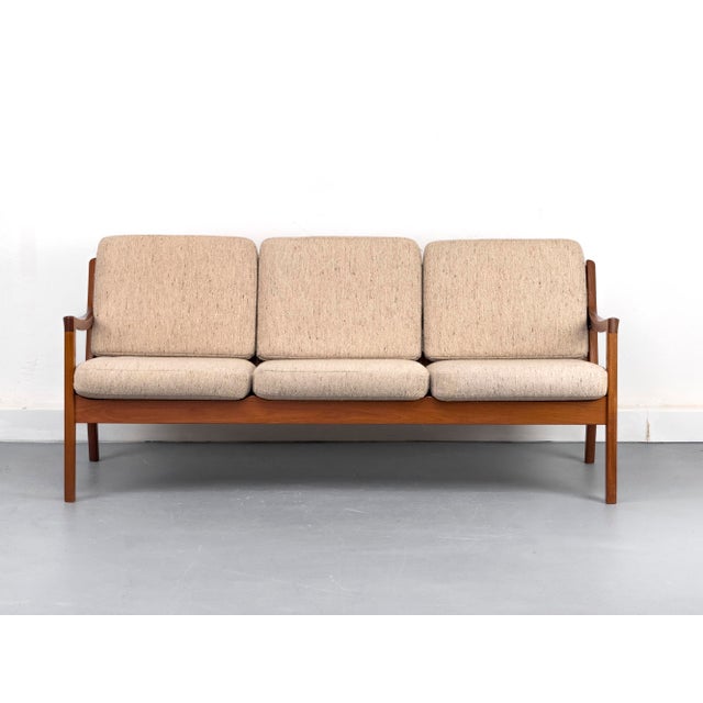 "Senator" lounge sofa in a beautiful finish, crafted from solid, reddish-brown teak with a lovely grain, designed by...