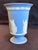 Classic Wedgwood Portland Blue Jasperware vase featuring crisp white neoclassical relief decoration. The main scene shows...