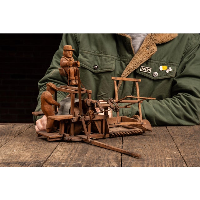 Handcrafted folk art whirligig constructed from carved and assembled wood elements, designed as a wind-powered kinetic...