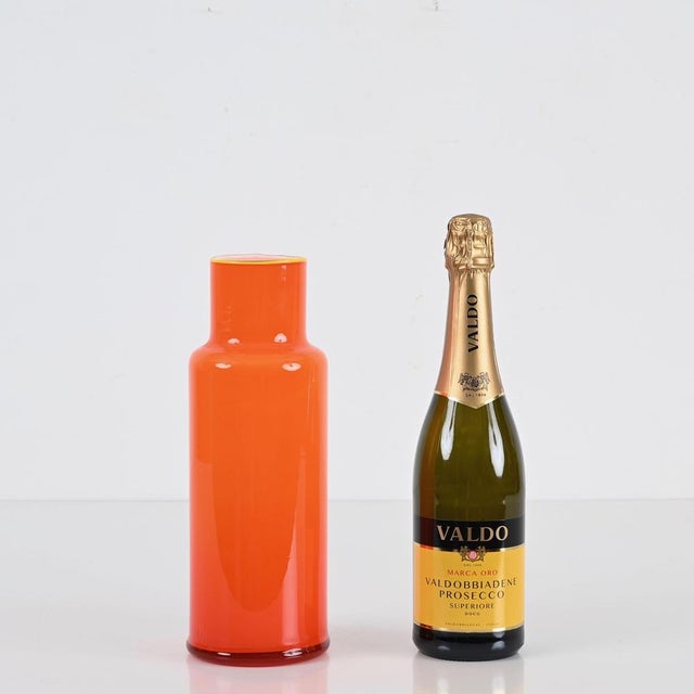Amazing midcentury Murano glass vase in a vibrant orange encased glass. This lovely piece was realized in Murano, Italy...