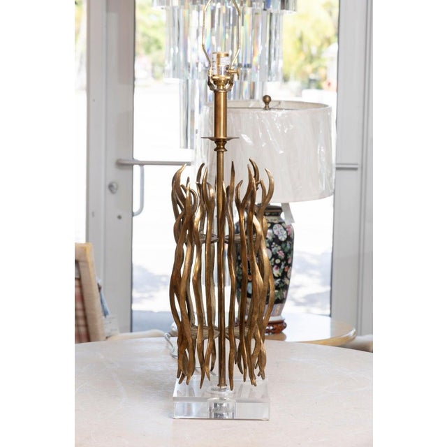 This is a striking organic modern table lamp crafted of sculptural cast brass, featuring an open cylindrical arrangement...