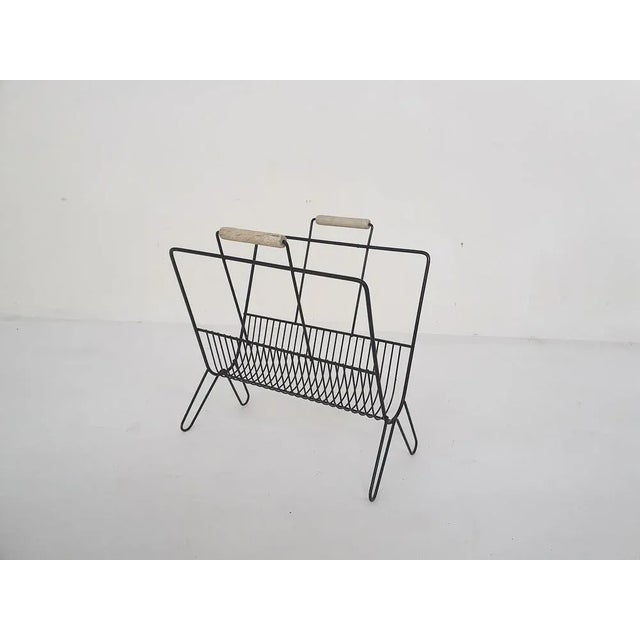 Black metal thread magazine stand with wooden handles.