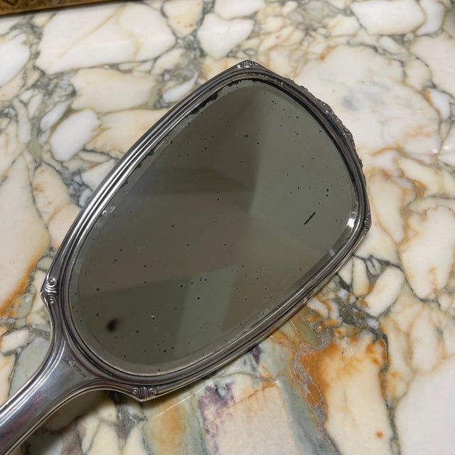 Beautiful large hand held sterling silver mirror. Heavy weight and feels very luxurious. The mirror side has small age...