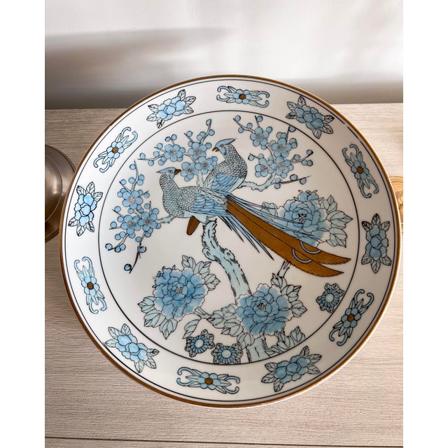 An elegant hand-painted Gold Imari decorative charger featuring two beautifully detailed birds perched among stylized...