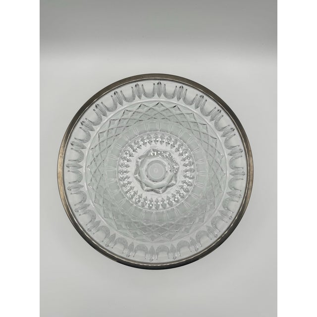 Clear, heavy cut crystal or glass serving bowl featuring a diamond-pattern upper section and vertical arched flutes along...