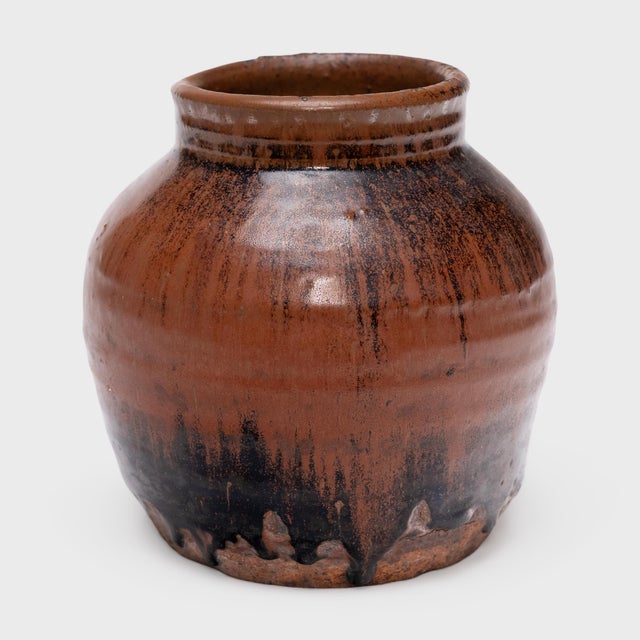 This antique Chinese jar from the early 20th century is cloaked inside and out with a beautiful drip glaze of red-brown...